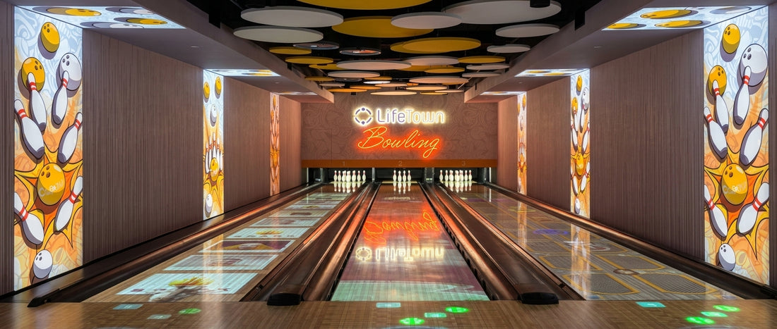 Fabric light boxes with bowling pin and ball graphics on bowling alley walls