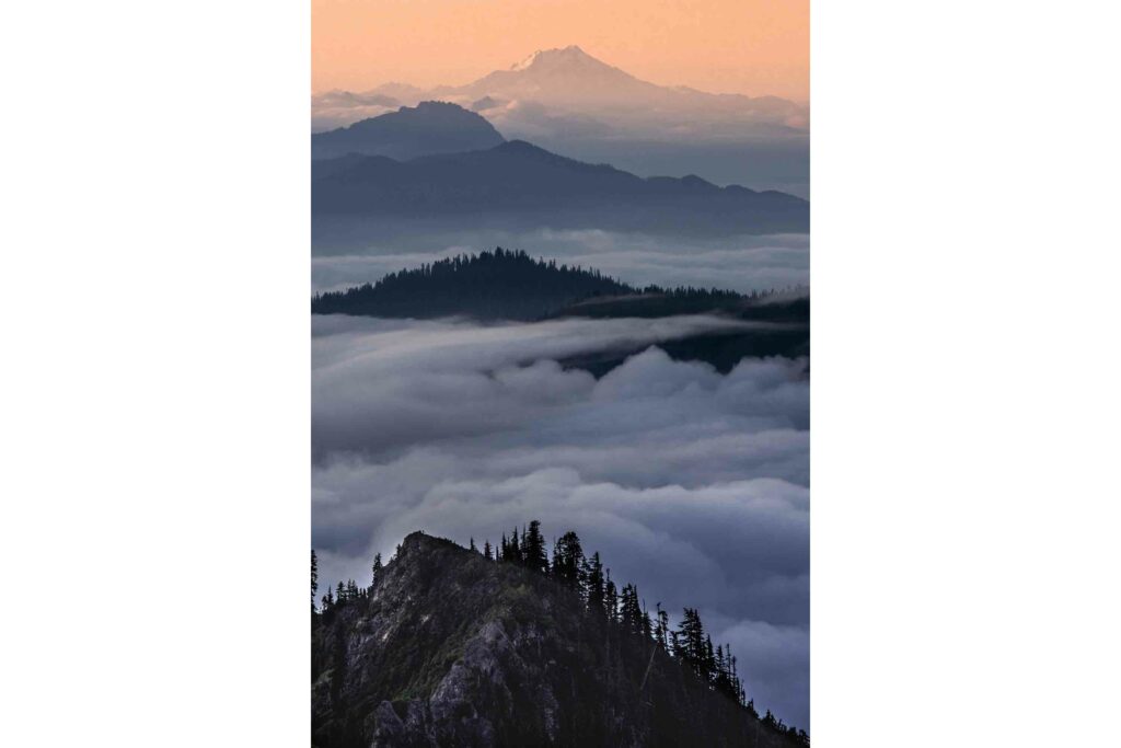Poster featuring misty, fog-shrouded mountains against a serene backdrop, evoking a sense of mystery and tranquility.
